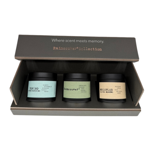 Raincouver® Collection 2oz candle gift set of 3 by Ollie & Co. in an open custom box — Tofino Storm Watching, Raincouver® and Whistler Alpine Meadows candles, lid reads ‘Where scent meets memory.’